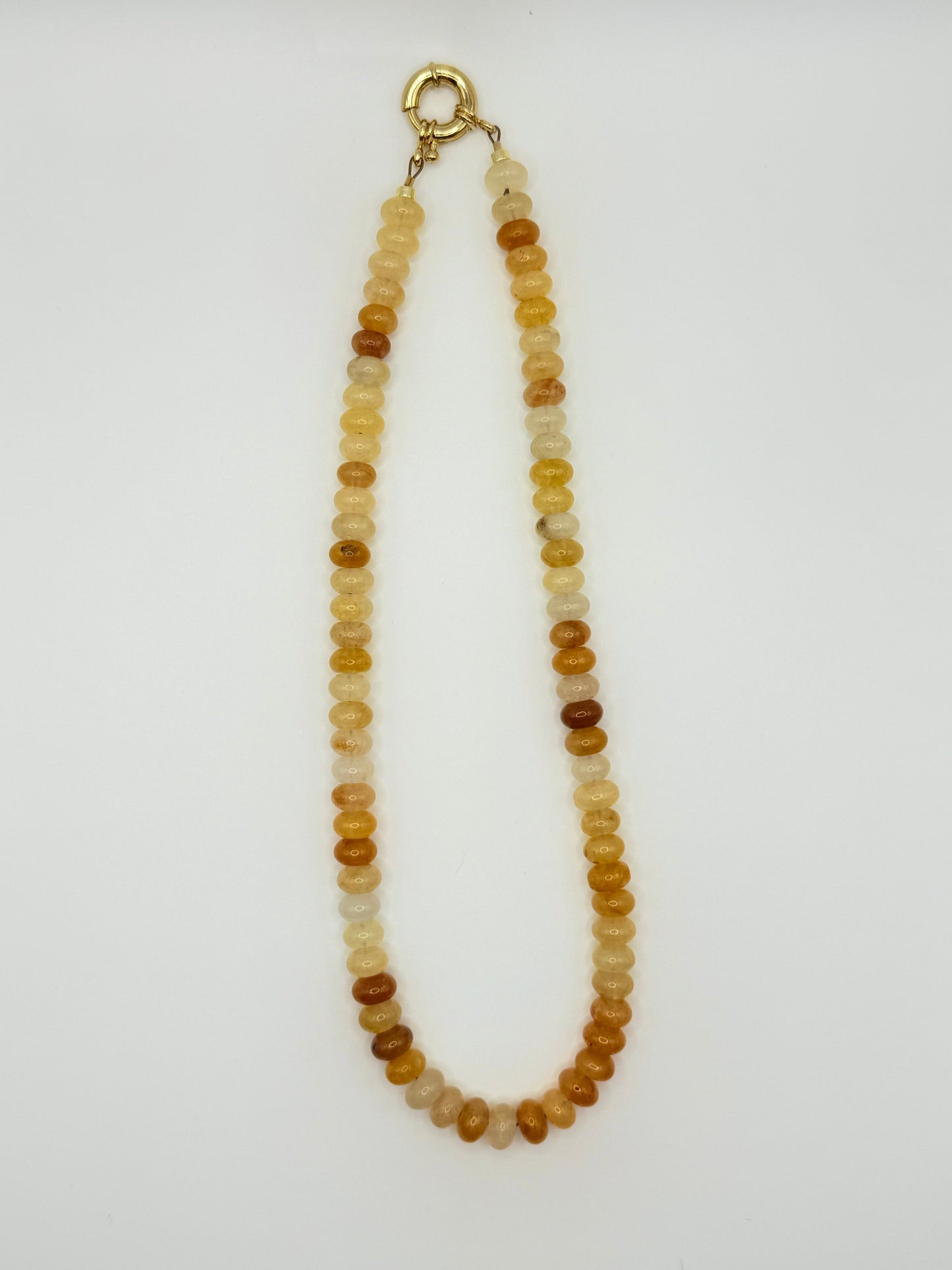 Gold beaded necklace featuring polished beads, perfect for adding a touch of sophistication to any outfit. 