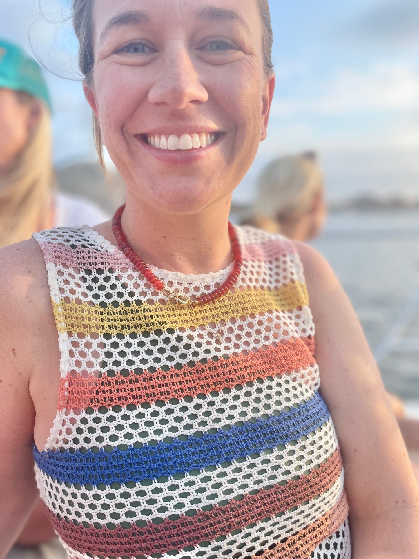 Person wearing a vibrant red beaded necklace, showcasing bold style and eye-catching fashion accessory.