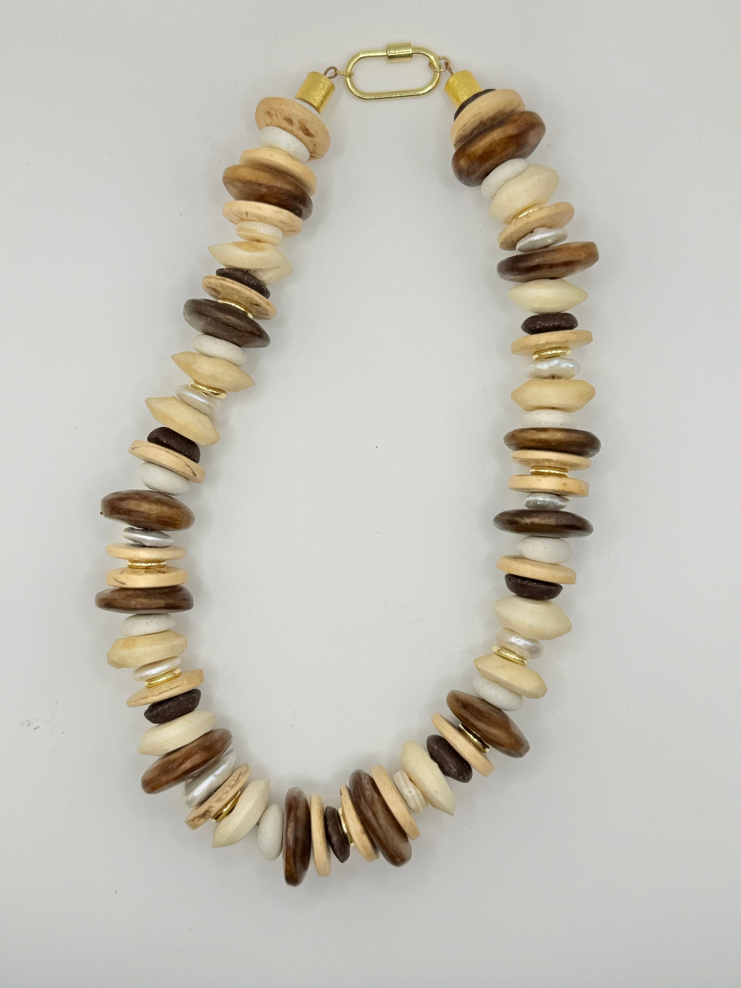 Trendy cream and brown wooden chunky necklace with large, textured beads, perfect for enhancing casual or bohemian styles.